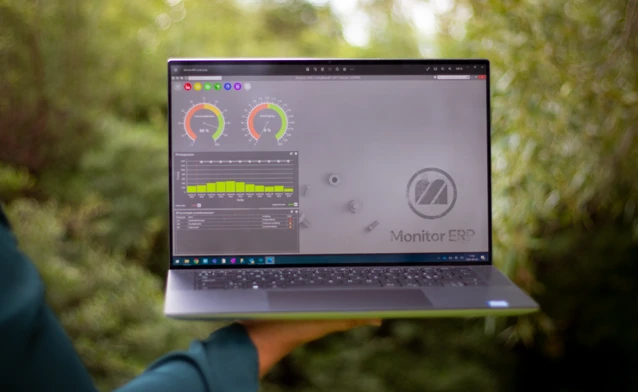 Illustration of Monitor ERP dashboards on a screen placed in nature, symbolizing sustainability.