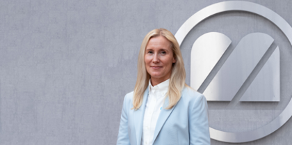A woman standing in front of a logo.