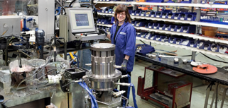 En kvinna står i en fabrik.