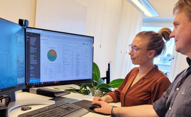 Ludzie przy biurku korzystający z systemu Monitor ERP