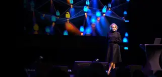 A woman standing on a stage in front of a crowd.