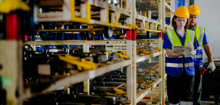 workers checking and inspecting metal machine part items for shipping. male and woman checking the store factory. industry factory warehouse. The warehouse of spare part for machinery and vehicles.