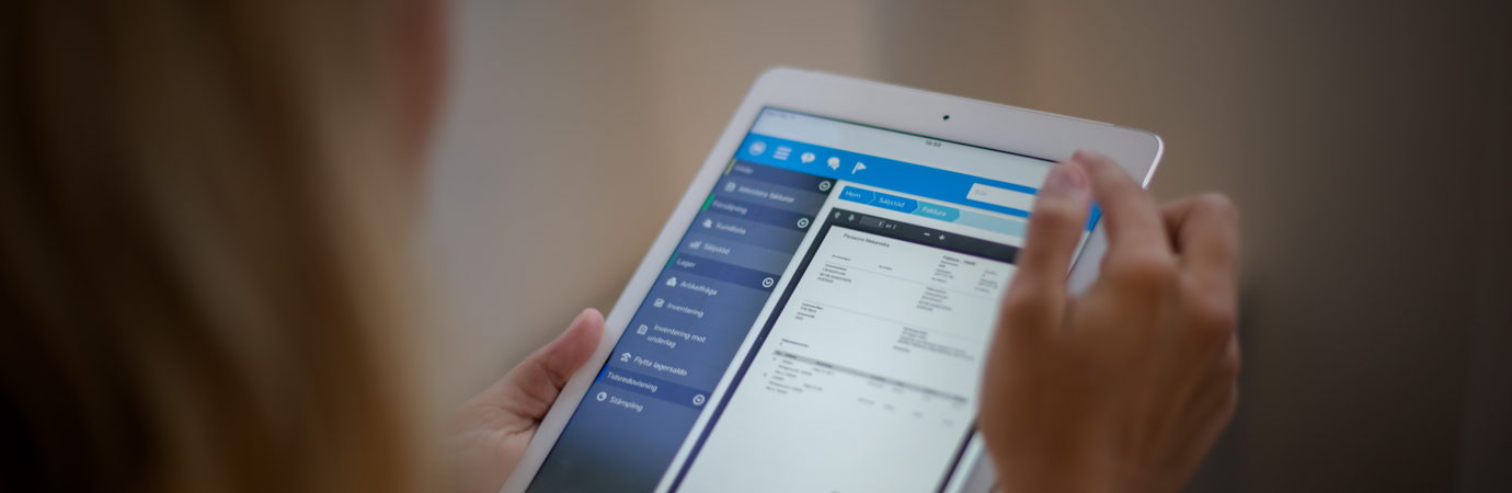 A woman is holding a tablet displaying a digital invoice. 
