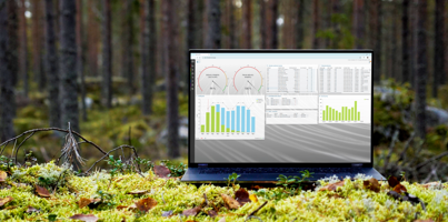 A laptop computer with Monitor ERP dashboard (sustainability functions) sitting on top of a moss covered field.