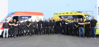 En grupp människor som står framför en skåpbil.