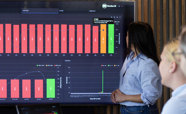 A woman at Monitor ERP giving a presentation to a group of people about Monitor BI (business intelligence)
