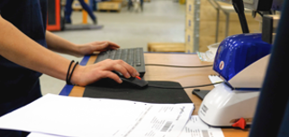 A man working on a computer in a factory.