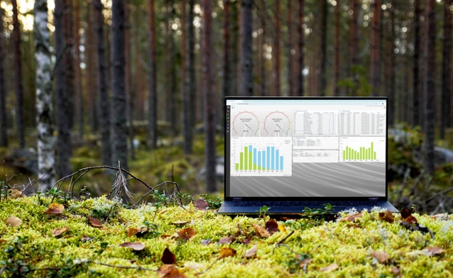 A laptop computer sitting on top of a moss covered field.