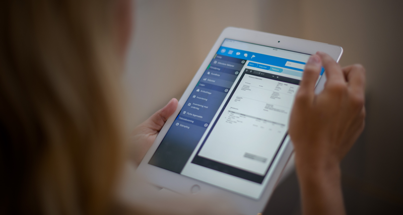 En kvinna håller ipad med Monitor ERP i sin hand.