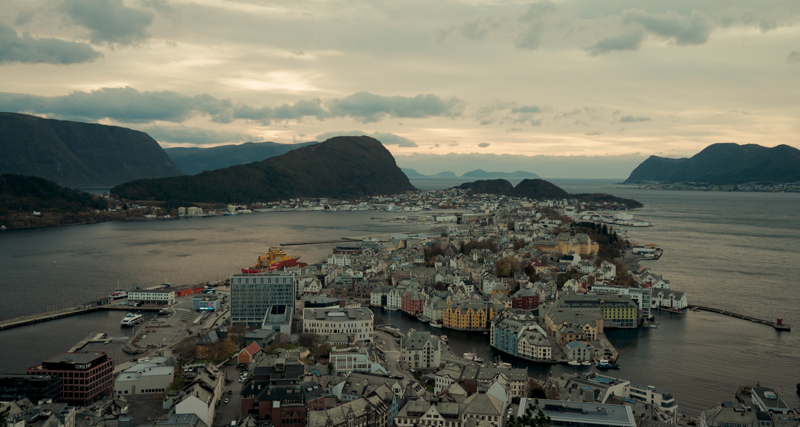 Oversiktsbilde av Ålesund, Norge, med fjorder, øyer og sentrum i kveldssol.