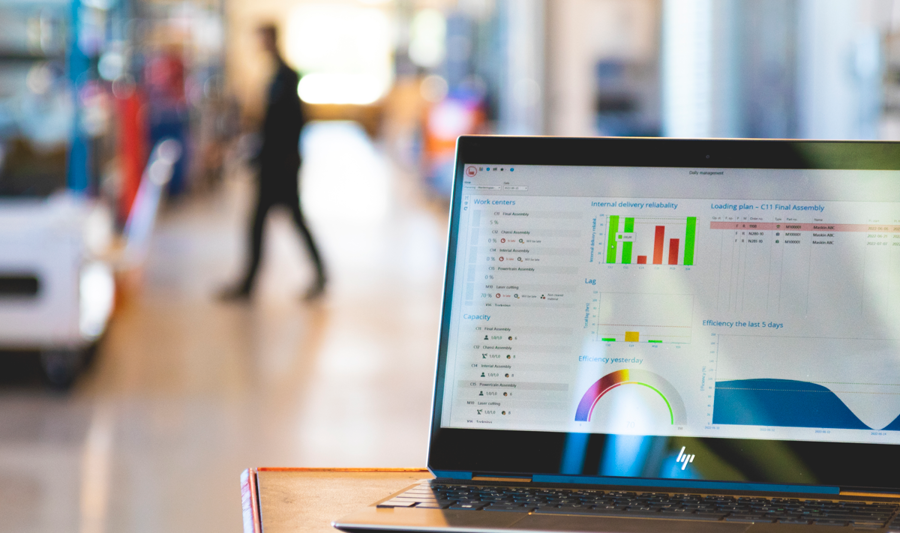 Monitor ERP dashboard displayed on a laptop in a factory environment.