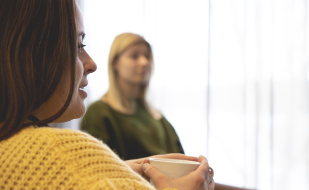 A woman holding a cup of coffee.