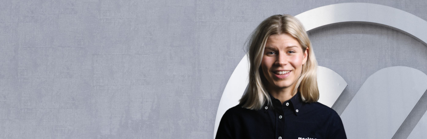 En kvinna står framför en vägg.