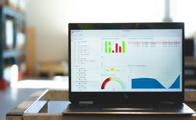 Monitor ERP dashboard displayed on a laptop in a factory environment
