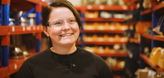 En kvinna står i en fabrik.