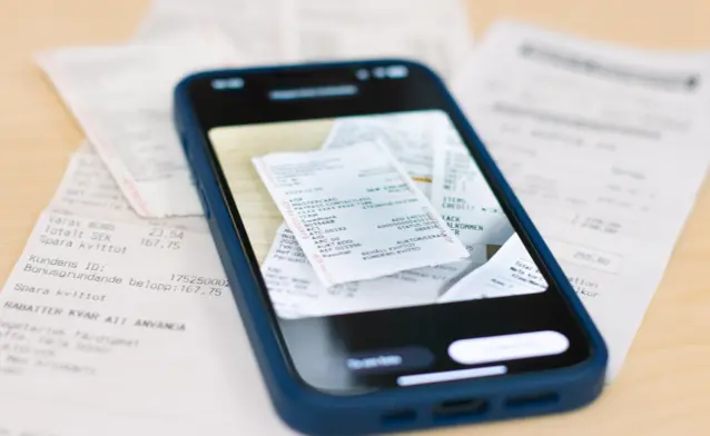 A smartphone scanning paper receipts