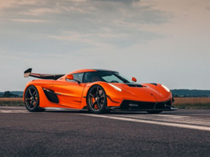 A bright orange sports car is parked on the road.