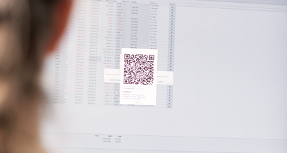 A woman looking at a computer screen with a qr code on it.