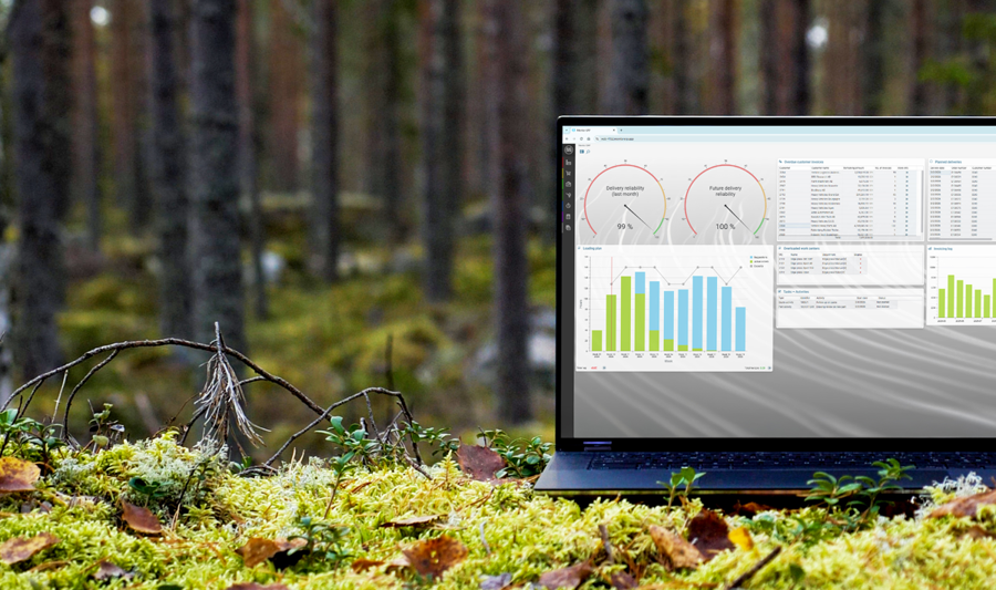 A laptop computer with Monitor ERP dashboard (sustainability functions) sitting on top of a moss covered field.