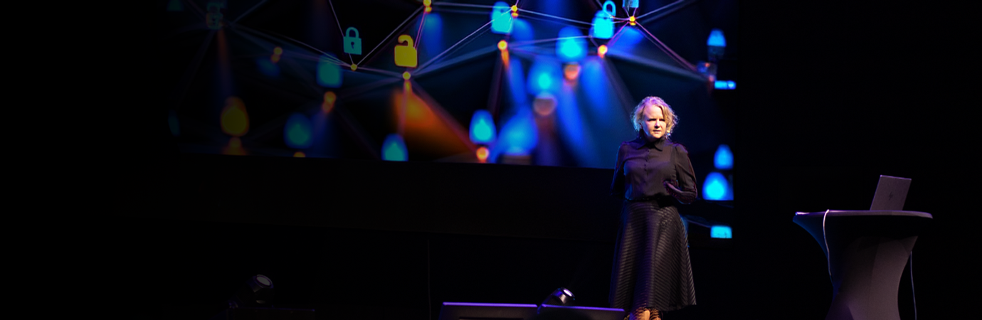 A woman standing on a stage in front of a crowd.