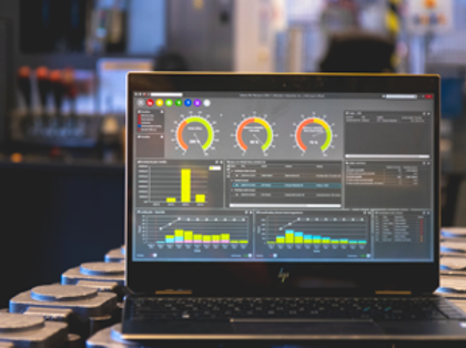 Monitor ERP dashboard displayed on a laptop in a factory environment