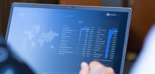 En person som sitter framför en bärbar dator med Monitor ERP instrumentpanel.
