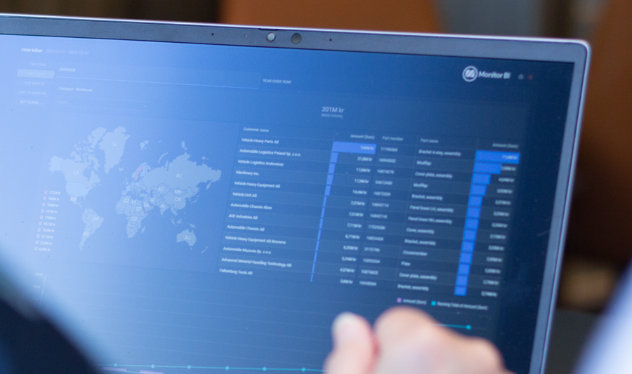 En person som sitter framför en bärbar dator med Monitor ERP instrumentpanel.