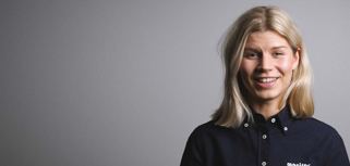 A woman in a black shirt is smiling.