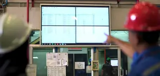 Tim PT Bumi Cahaya Unggul memantau data kehadiran dan aktivitas kerja karyawan di layar menggunakan Monitor ERP