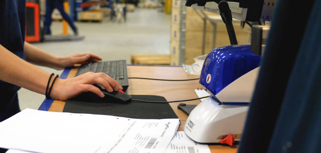 A man working on a computer in a factory.