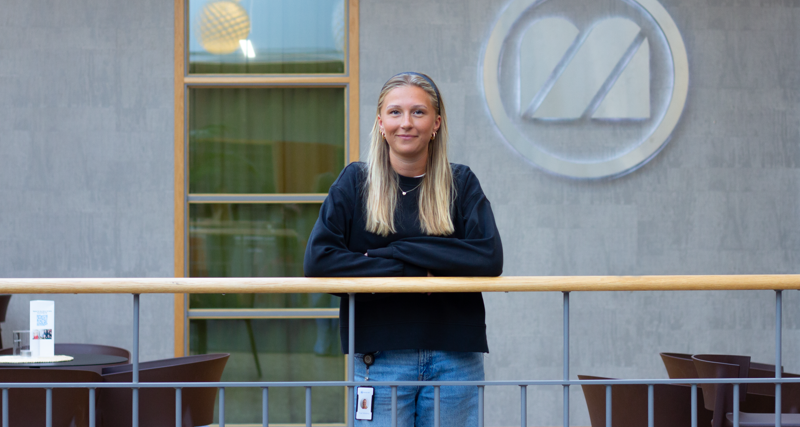 Troja Stenström Schönborg står och lutar sig mot ett räcke inne på Monitors huvudkontor i Hudiksvall.