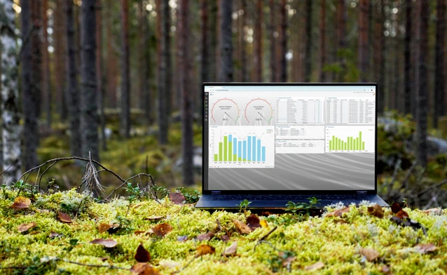 A laptop computer sitting on top of a moss covered field.
