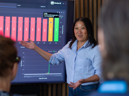 A woman at Monitor ERP giving a presentation to a group of people about Monitor BI (business intelligence)