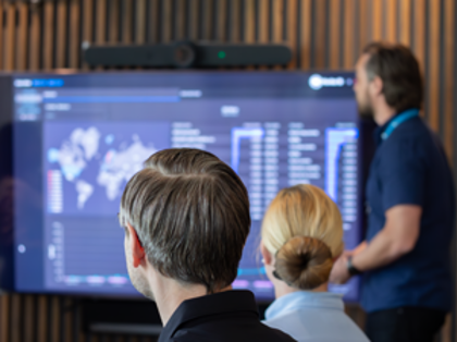 En man från Monitor ERP håller en presentation för en grupp människor om Monitor ERP