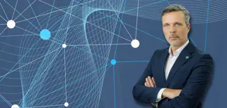 Maciej Swienton, CEO Monitor ERP Poland, on blue background with dots.