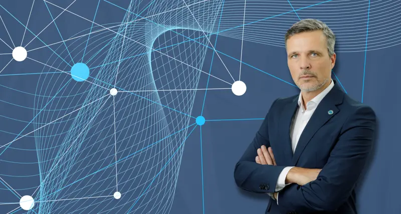 Maciej Swienton, CEO Monitor ERP Poland, on blue background with dots.