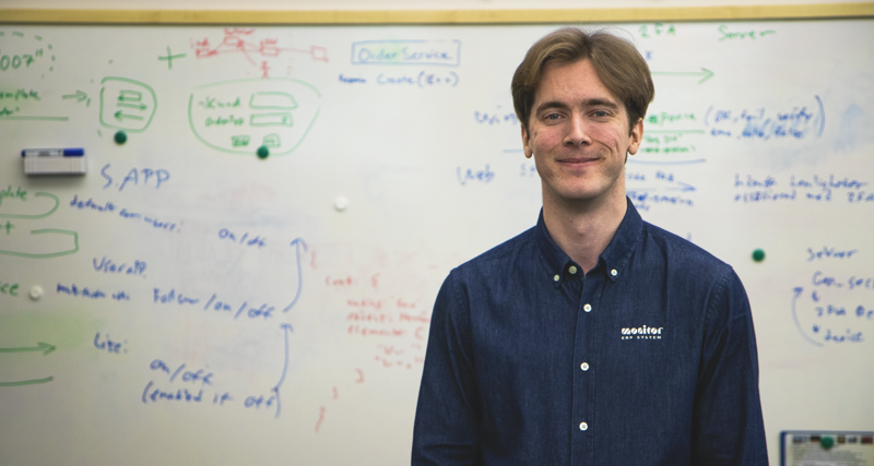 Viktor Rosvall, Utvecklare på Monitor, står framför en white board. 