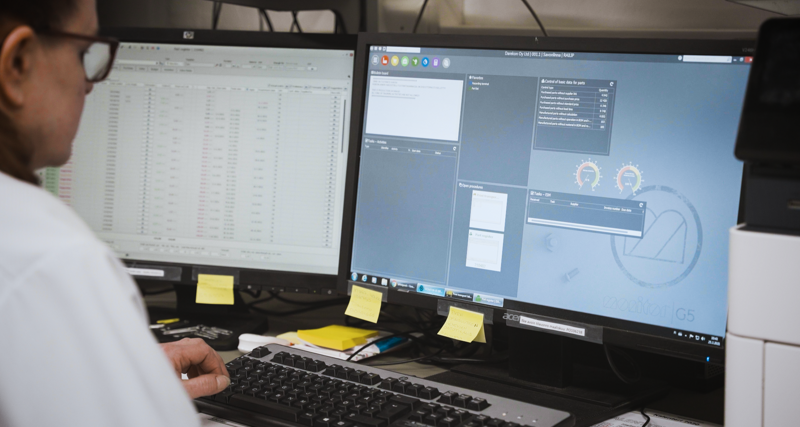 A man sitting in front of two computer monitors.