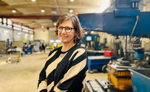 En kvinna står i en fabrik.