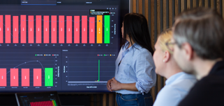 A woman at Monitor ERP giving a presentation to a group of people about Monitor BI (business intelligence)