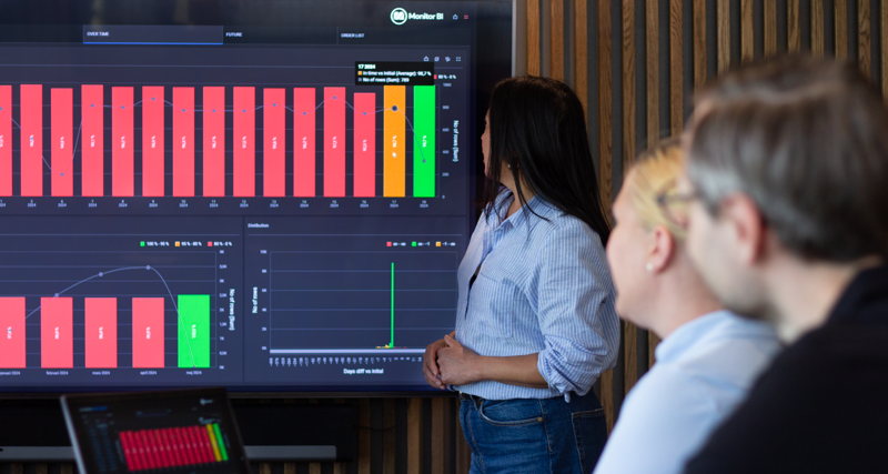 A woman at Monitor ERP giving a presentation to a group of people about Monitor BI (business intelligence)