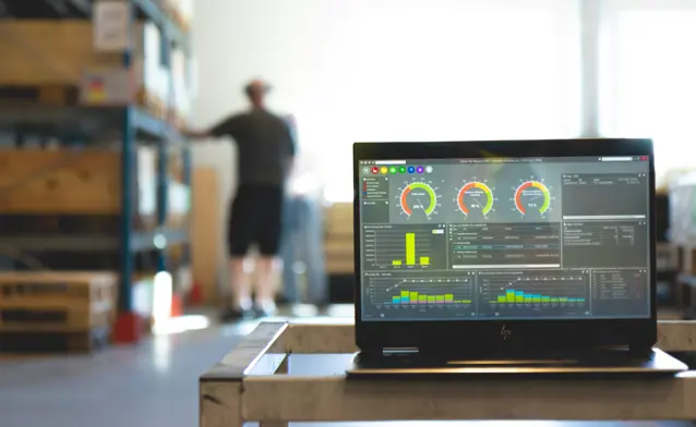 Monitor ERP dashboard displayed on a laptop in a factory environment
