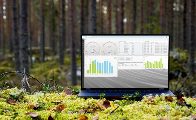 A laptop computer sitting on top of a moss covered field.