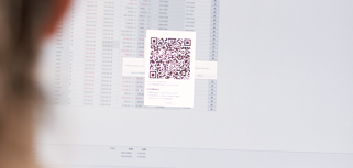 A woman looking at a computer screen with a qr code on it.