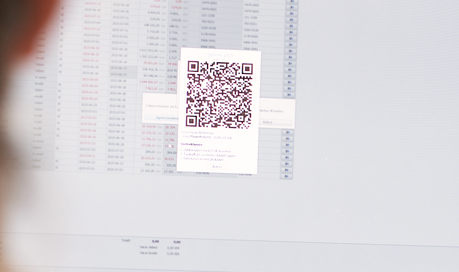 A woman looking at a computer screen with a qr code on it.