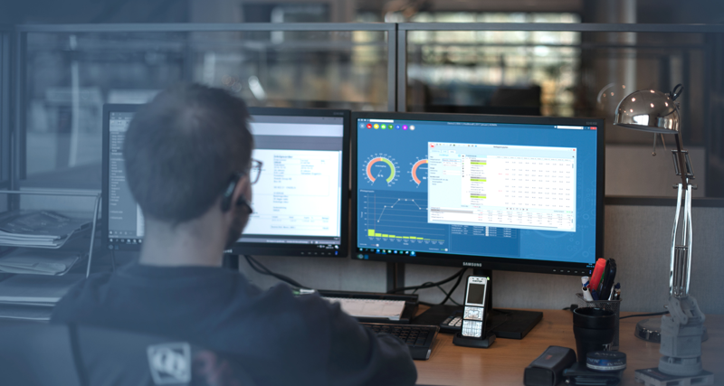 A man sitting in front of a computer monitor.