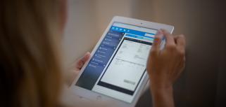 A woman is holding a tablet displaying a digital invoice. 