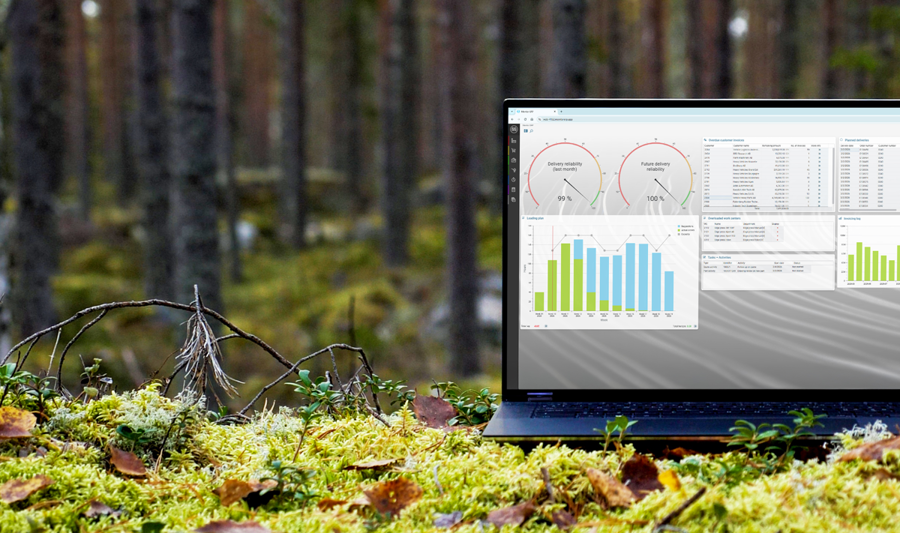 A laptop computer with Monitor ERP dashboard (sustainability functions) sitting on top of a moss covered field.