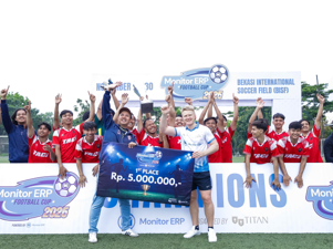 A group of people, appearing to be a football team, celebrates their victory at the Monitor ERP Football Cup 2025 event.