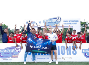 A group of people, appearing to be a football team, celebrates their victory at the Monitor ERP Football Cup 2025 event.